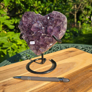 Amethyst Druse Amethyst Geode in Herzform mit Metallsockel 18x15x10cm - NR-37 auf einem Holzuntergrund.