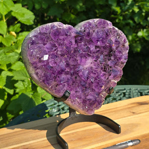 Amethyst Druse Amethyst Geode in Herzform mit Metallsockel 23x19x12cm - NR-18 auf einem Holztablett.