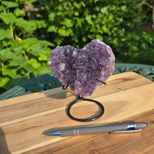 Amethyst Druse Amethyst Geode in Herzform mit Metallsockel 12x11x9cm - NR-46 auf Holzuntergrund mit Kugelschreiber