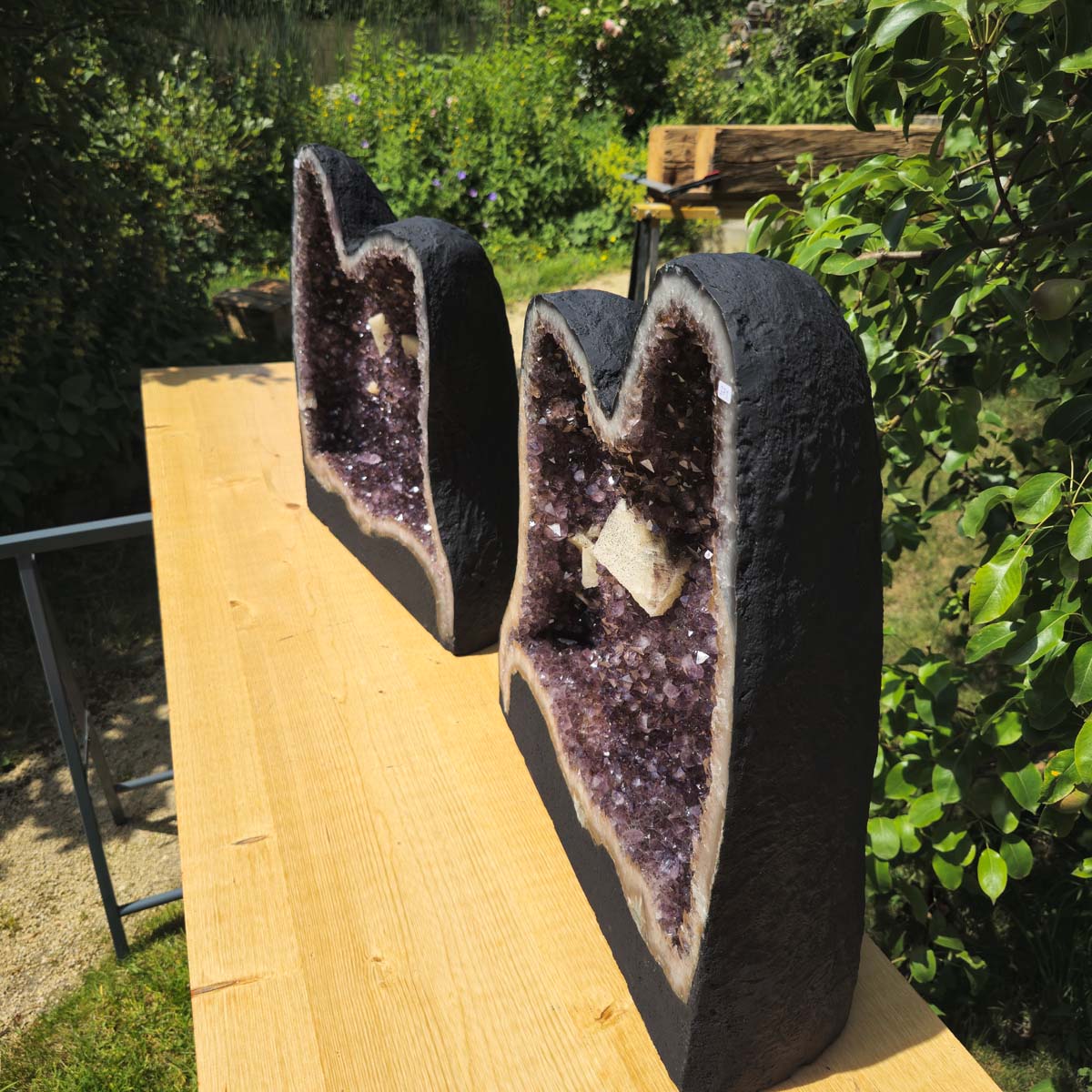Amethystdrusen Paar 1A - 89kg - Höhe 51cm - Harmonie und Entspannung - UNIKAT 370 auf einem Holztisch im Garten