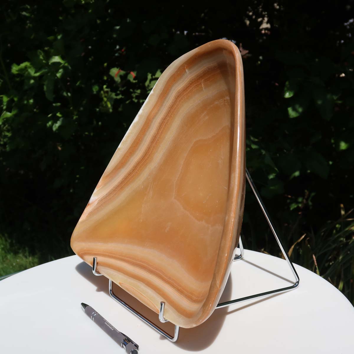 Aragonit Stein Schale - (Onyxmarmor) - 30x31cm - handgeschliffen und poliert - Nr. 61 auf einem Tisch im Freien.