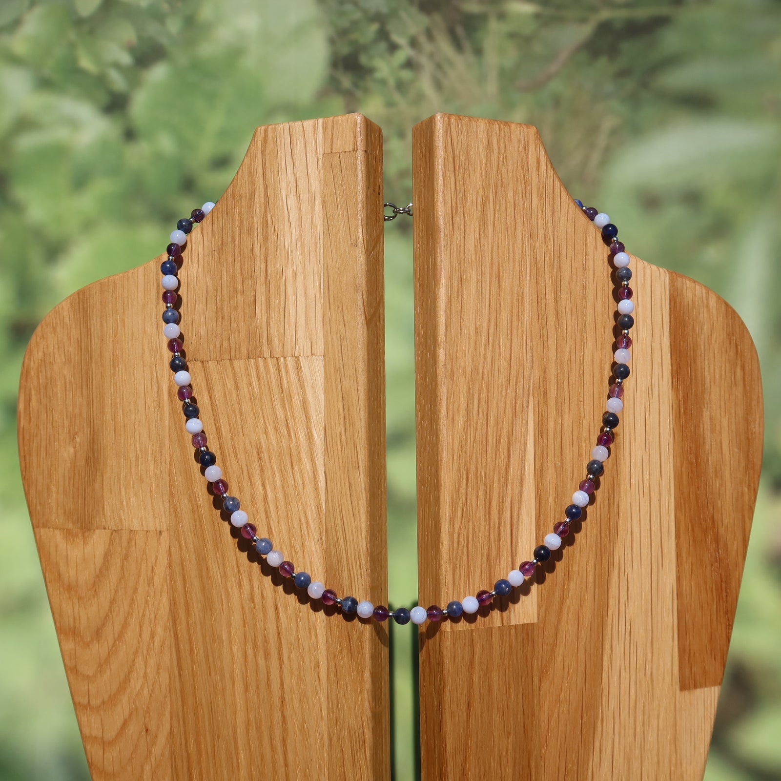 Chalcedon, Amethyst und Sodalith Kette auf Holzständer, zeigt sanfte Eleganz und harmonischen Farbverlauf.
