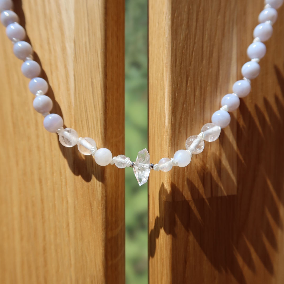 Chalcedon, Bergkristall und Labradorit weiße Kette auf Holzständer, Natürlichkeit und Eleganz vereint.