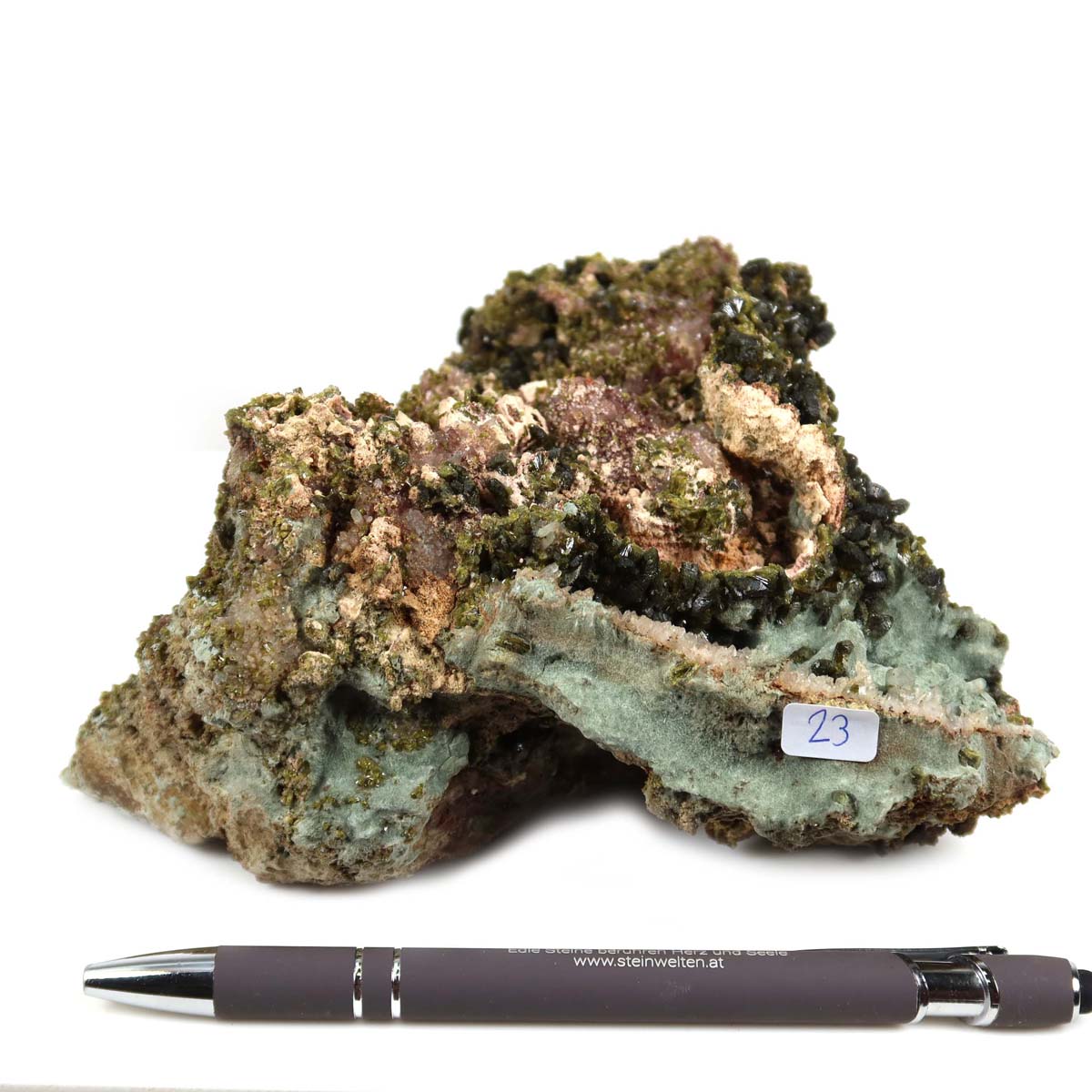 Epidot Kristall aus Marokko Nr. 23, 14x12x6 cm, auf weißem Hintergrund mit Kugelschreiber zur Größenreferenz.