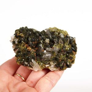 Hand holding Epidot and Bergkristall crystal cluster, mineralien kaufen, from Morocco, showcasing natural harmony and clarity.