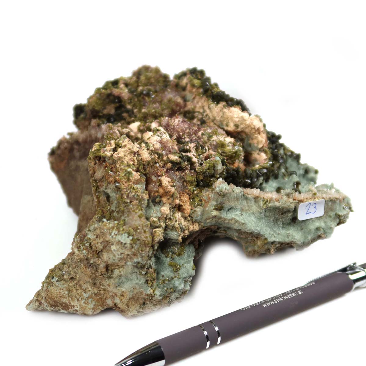 Epidot Kristall aus Marokko Nr. 23, 14x12x6 cm, auf weißem Hintergrund mit Kugelschreiber zur Größenreferenz.