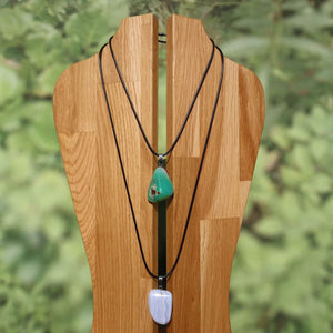 Halsband mit geflochtenem Baumwollband und Krokodilverschluss, verschiedene Anhänger in grün und weiß.