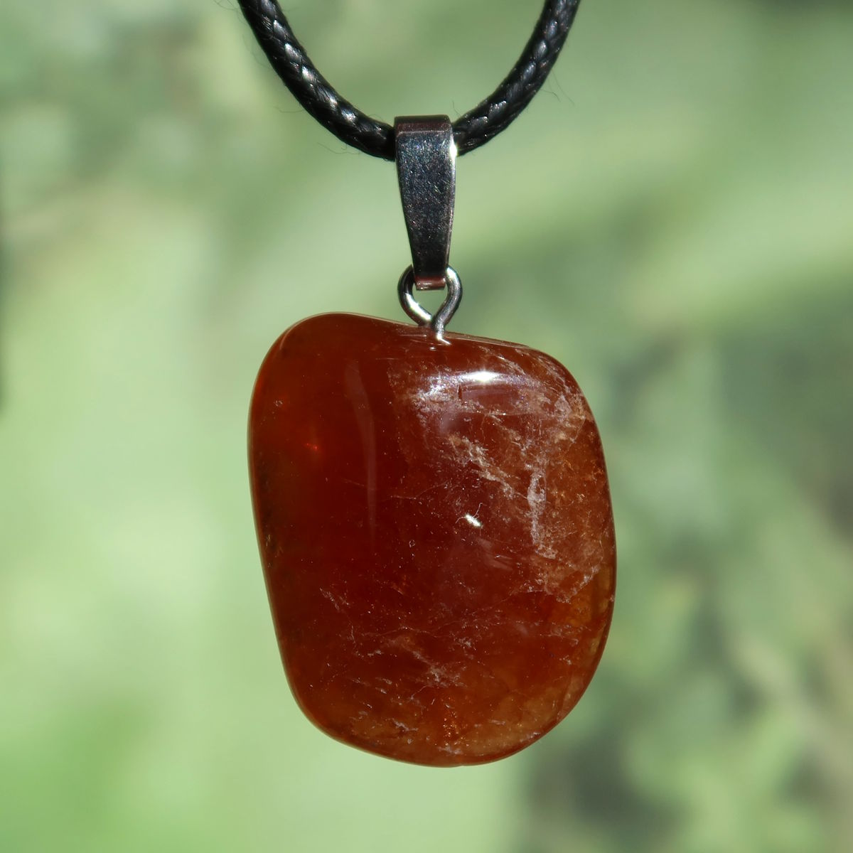 Granat Hessonit Anhänger - Selbstliebe und Kraft - Nr. 7, bernsteinfarbener Steinanhänger auf schwarzem Lederhalsband.