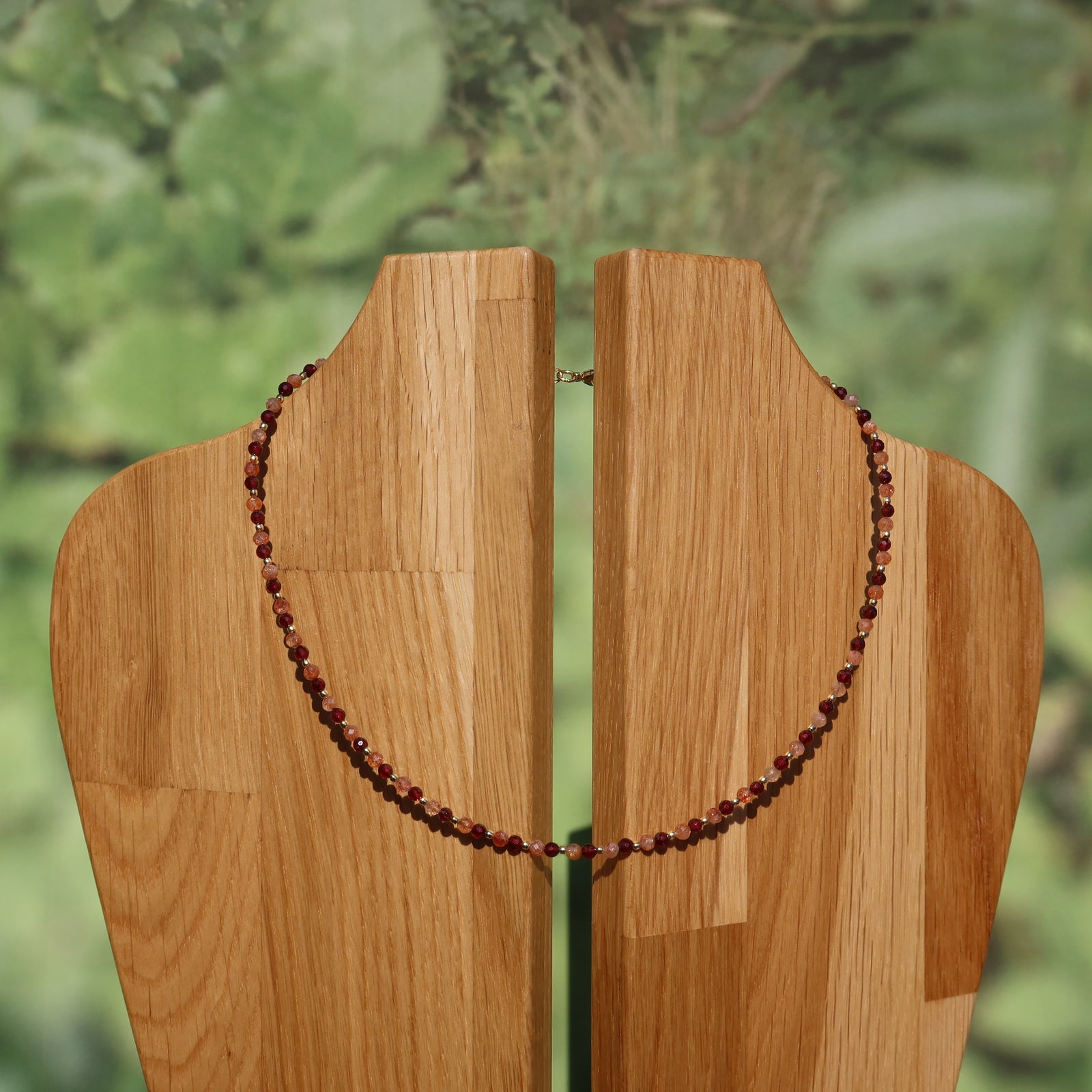 Granat mit Sonnenstein Edelsteinkette - Optimismus und Stabilität - Nr. 17 auf Holzstatue präsentiert