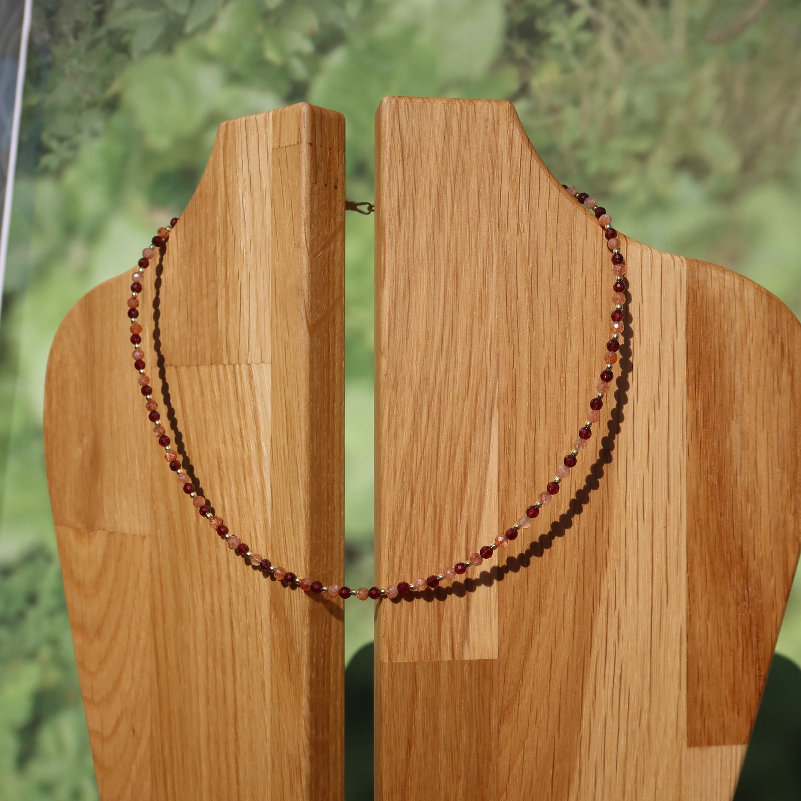 Granat mit Sonnenstein Edelsteinkette - Optimismus und Stabilität - Nr. 17 auf Holzstatue präsentiert