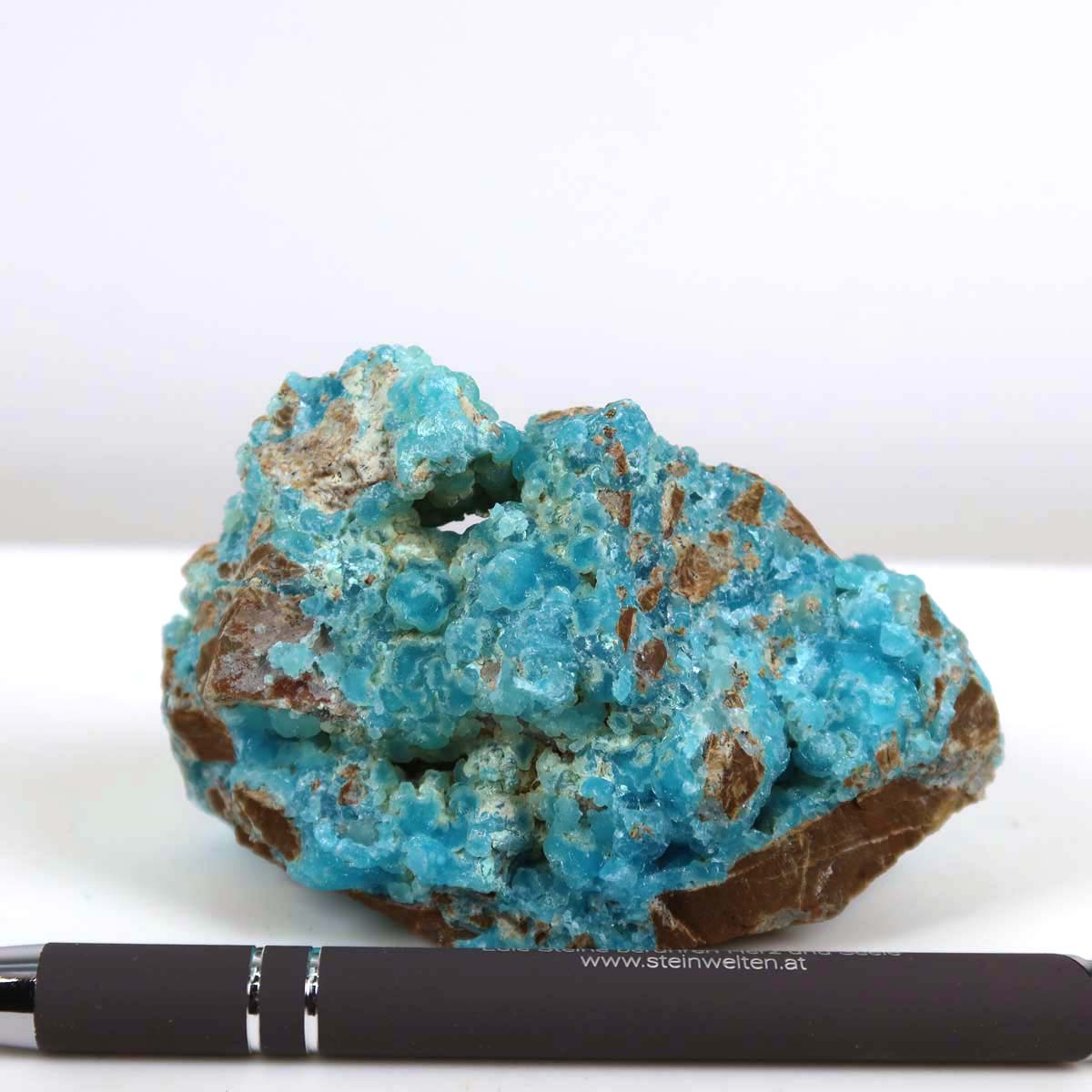 Hand holding Hemimorphit Rohstein with vibrant turquoise and white hues, showcasing natural crystal structure, unique collector's mineral.