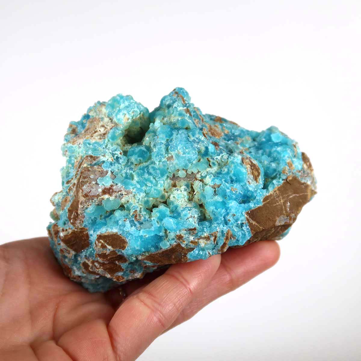 Hand holding Hemimorphit Rohstein with vibrant turquoise and white hues, showcasing natural crystal structure, unique collector's mineral.