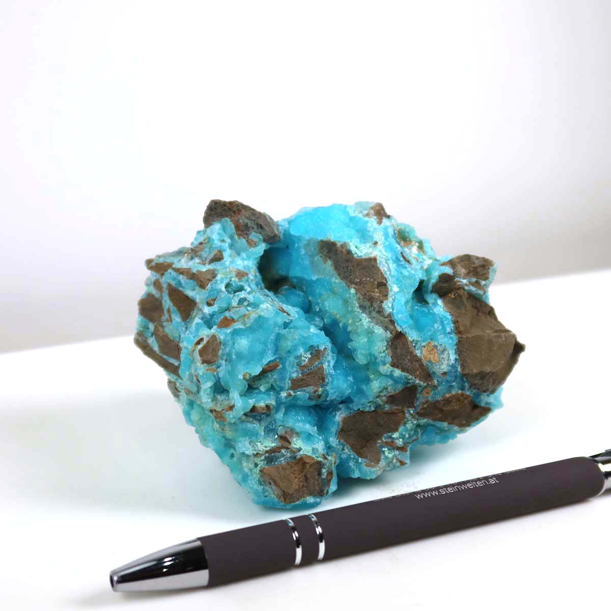 Hemimorphit Rohstein mit kräftigen türkisfarbenen Strukturen, Unikat Nr. 2, neben einem Stift zur Größenreferenz, 9x8x5 cm.