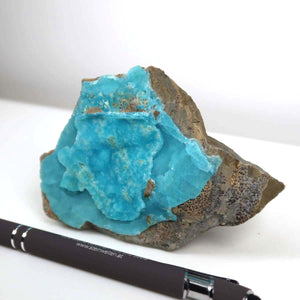 Hemimorphit Rohstein in natürlichen türkisblauen Farben, 10x7x3 cm, Sammlermineral Unikat Nr. 8, neben einem Stift, auf weißem Hintergrund.