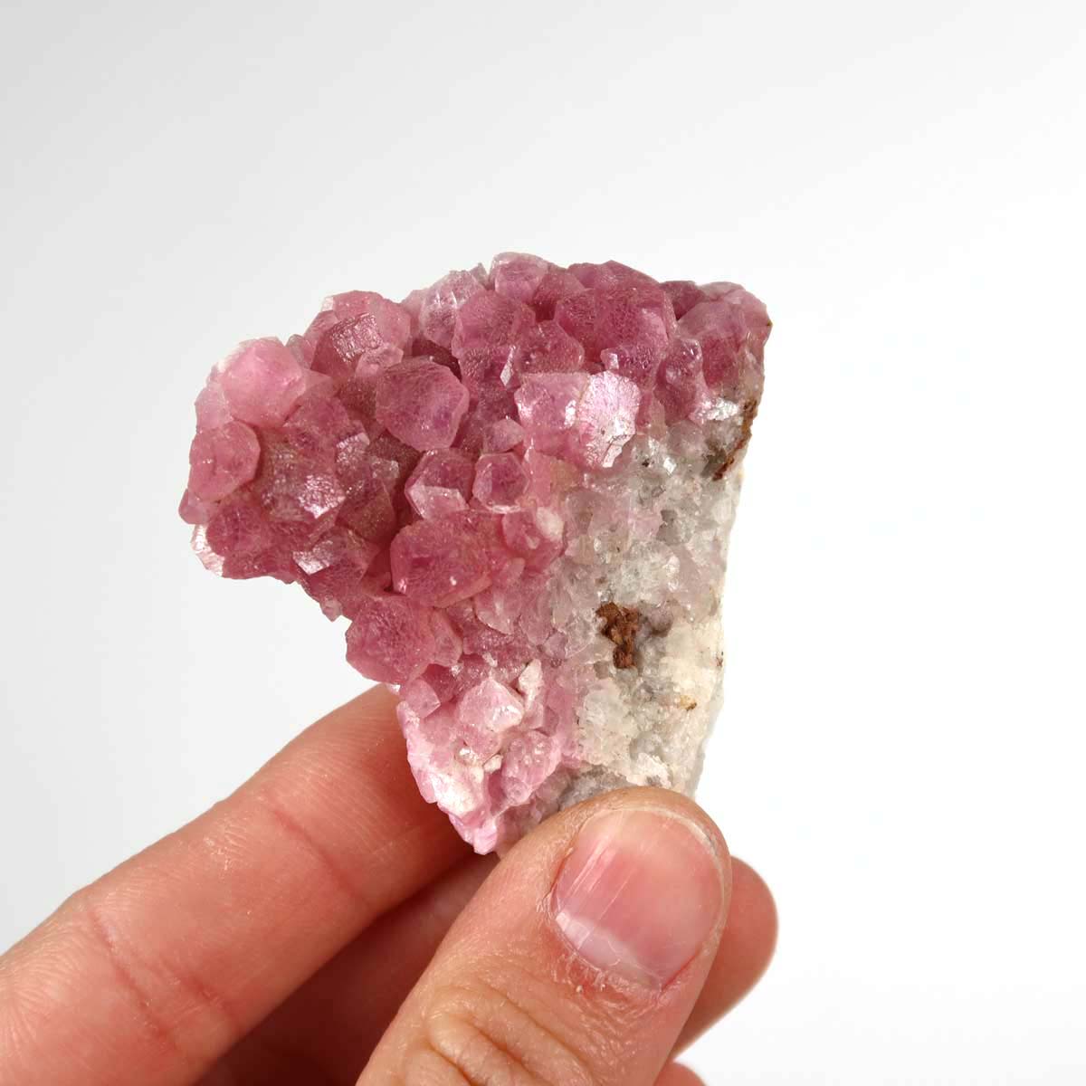 Hand holding Kobalt Calcit raw mineral stone 5x4x2 cm with pink hue and natural crystal structure, perfect for collectors.