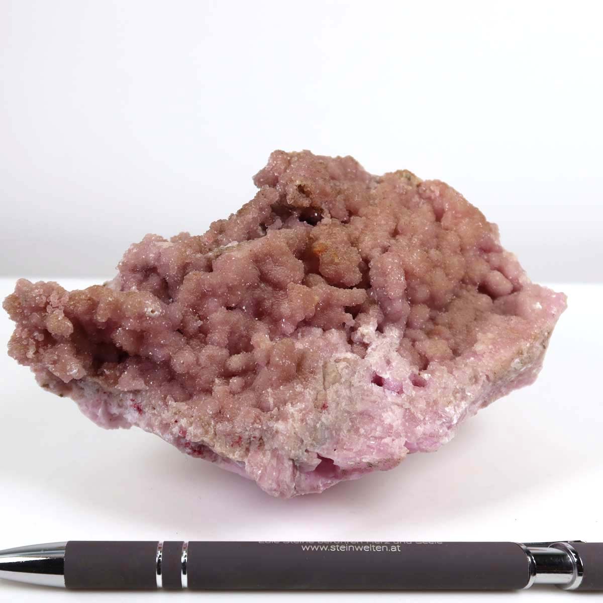 Kobalt Calcit raw mineral stone from Morocco in natural pink, showcasing unique crystal structure next to a pen for scale.