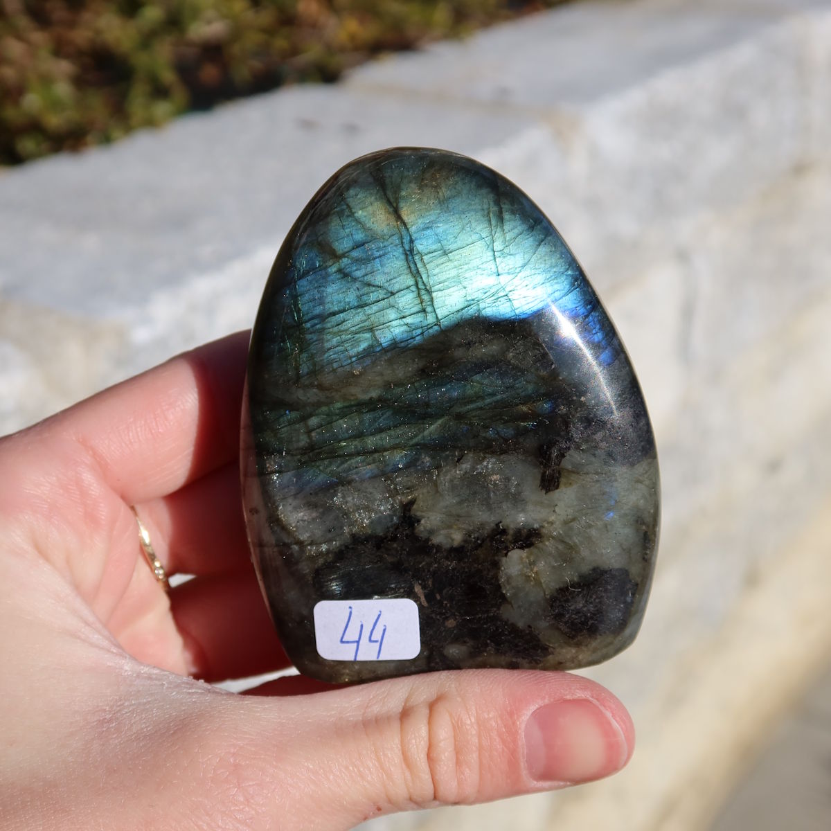 Labradorit Freiform poliert - 7x5cm - Intuition und Kreativität Nr.44; zeigt lebhafte Blau- und Grüntöne im Sonnenlicht.