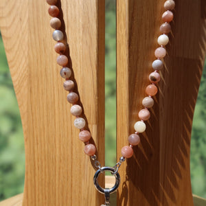 Mondstein Kette geknüpft in sanftem Design und natürlichem Schimmer, auf Holzdisplay präsentiert.