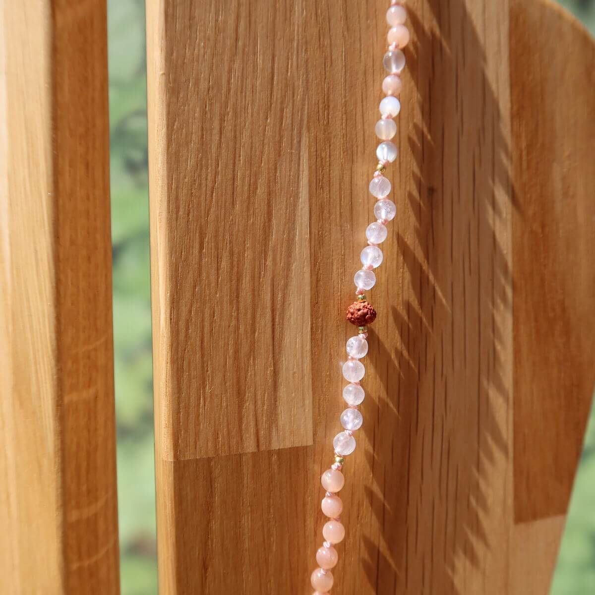 Schöne lange Kette mit Mondstein, Labradorit und Rudraksha auf Holzständer präsentiert.
