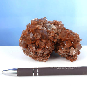 Natürliche rohe Aragonit Kristall Stufe aus Marokko, 11x8 cm, auf Tisch neben Stift. Ideal für Sammler und Liebhaber natürlicher Mineralien.