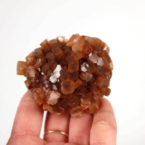 Hand holding natural raw Aragonite crystal cluster from Morocco, unique piece for collectors and mineral enthusiasts, 6x5 cm.