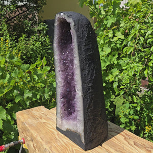 Amethyst Druse – Geode - 54x22x22cm und 27kg – Steinwelten OG - Nr. 56, unique home decor piece on wooden platform.