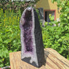 Amethyst Druse – Geode - 34x15x13cm und 7,8kg – Steinwelten OG - Nr. 263 in a garden setting.