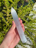 Selenit Massage Griffel mit Spitze- Akupunktur-Massagestab - 15cm, hand holding translucent crystal against leafy background