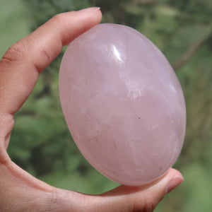 Rosenquarz Handschmeichler - Selbstliebe und Harmonie - Nr. 10 in sanften Rosatönen in der Hand.