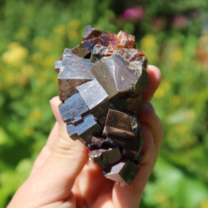 Vanadinit - Natürliche Kristallstufe aus Marokko 8x4x4cm - 0,3kg Nr.9 in der Hand gehalten vor grünem Hintergrund.