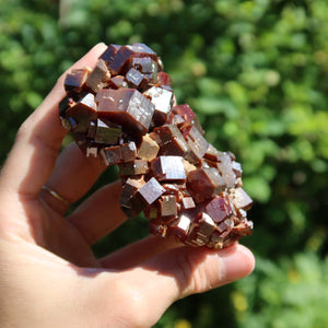 Vanadinit - Natürliche Kristallstufe aus Marokko 8x6x3cm - 0,29kg Nr.29 in der Hand mit grünen Hintergrund.